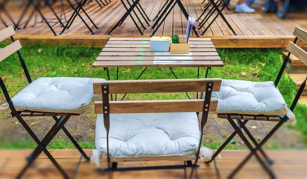 Mesa de madeira e cadeira no jardim do café — Fotografia de Stock