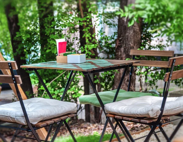 Mesa de madeira e cadeira no jardim do café — Fotografia de Stock