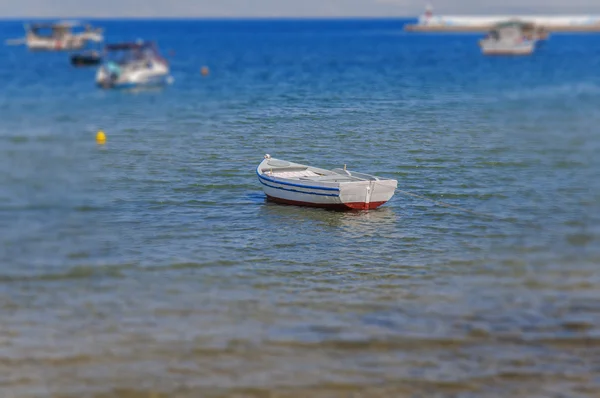 Beyaz ve mavi eski balıkçı teknesi kıyıya bağlı — Stok fotoğraf