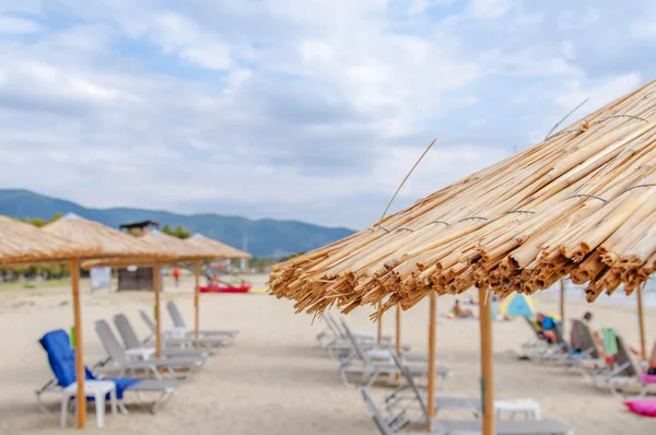 Reed paraplyer beach med suddiga strand Stäng — Stockfoto