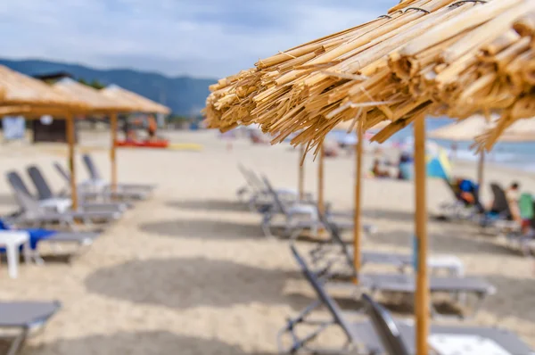 Reed paraplyer beach med suddiga strand Stäng — Stockfoto