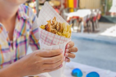 Patates kızartması ile Yunan gyro tutan kız masada kapat