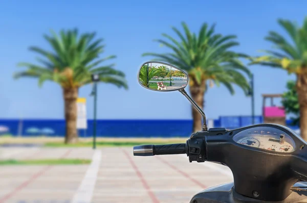 Зеркало мотоцикла с размытым морским фоном — стоковое фото