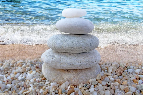 Stack di pietre zen sulla spiaggia e sfondo onda — Foto Stock