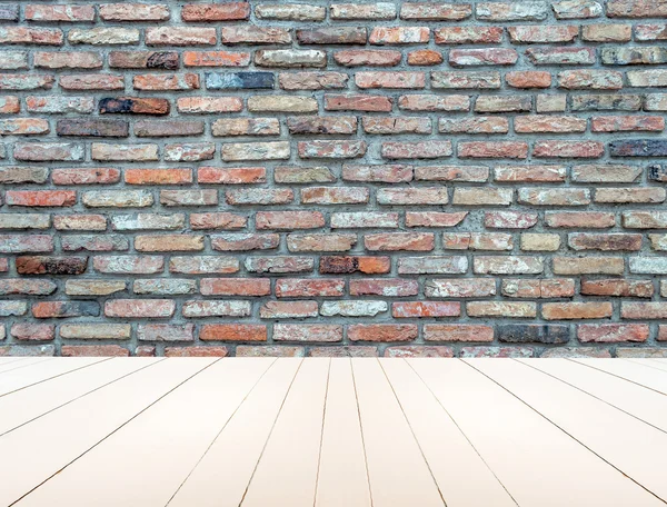 Textured old brick wall with white wooden floor inside