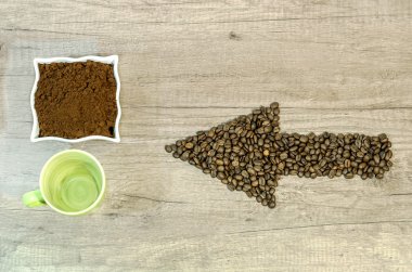 Ok biçiminden taze çekilmiş kahve ve ahşap adam boş fincan kahve çekirdekleri