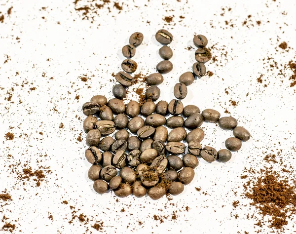 Xícara de café com fumaça feita de feijão de café polvilhado com café fresco no fundo branco — Fotografia de Stock