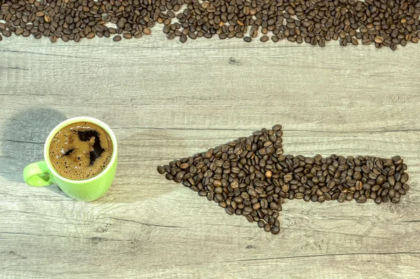 Seta dos grãos de café com xícara de café em fundo de madeira — Fotografia de Stock