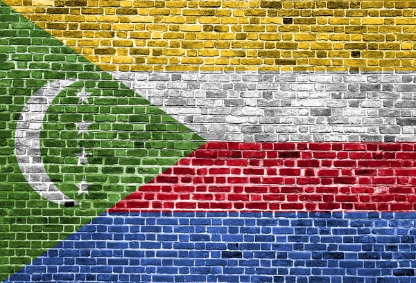 Téglafal, háttér textúra festett Comore-szigetek zászlaja — Stock Fotó