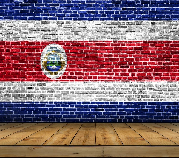 Bandera de Costa Rica pintada sobre pared de ladrillo con suelo de madera — Foto de Stock