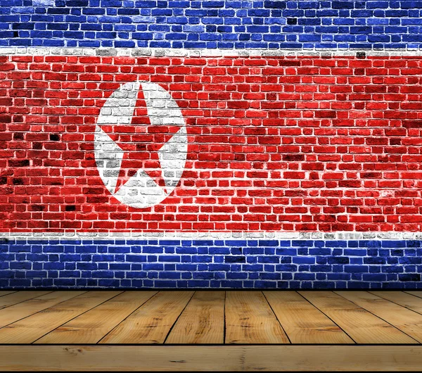 木製の床とレンガの壁に描かれた北朝鮮の旗 — ストック写真
