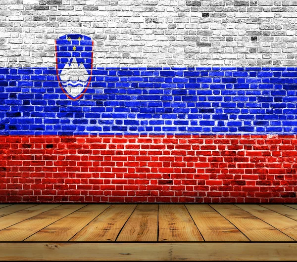 Sloveniens flagga målade på tegelvägg med trägolv — Stockfoto