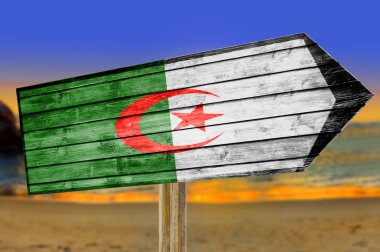 Algeria Flag wooden sign on beach background clipart