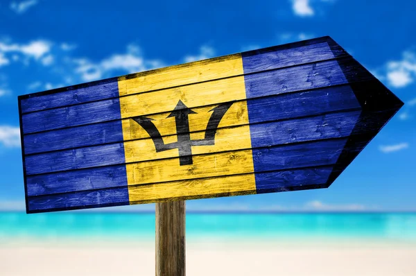 巴巴多斯国旗木制的桌子上签署上海滩背景 — 图库照片