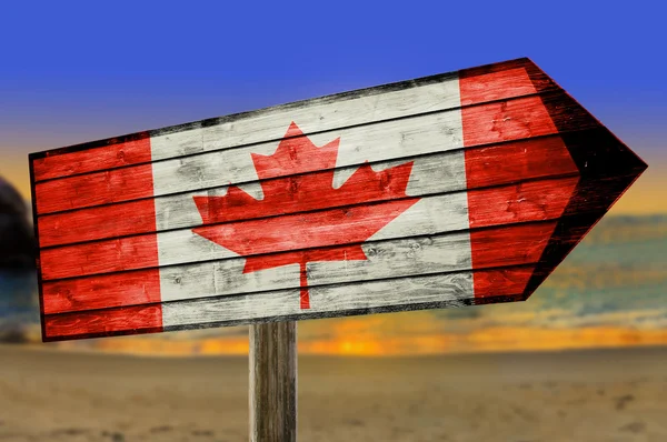 Bandeira do Canadá em placa de mesa de madeira no fundo da praia — Fotografia de Stock