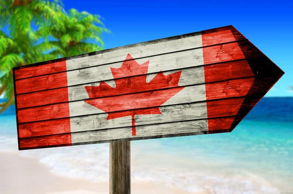 Bandeira do Canadá em placa de mesa de madeira no fundo da praia — Fotografia de Stock