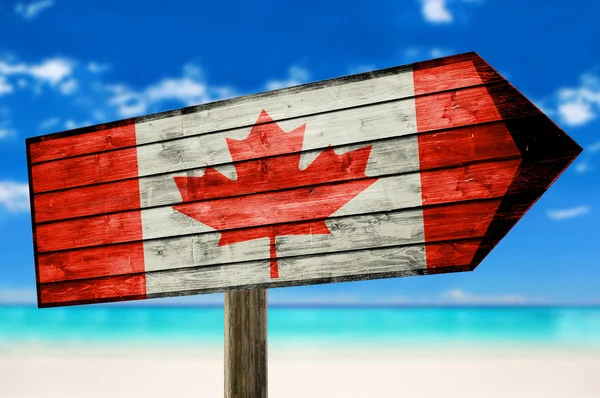 Bandera de Canadá sobre tabla de madera cartel sobre fondo de playa — Foto de Stock