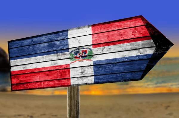 Bandera de República Dominicana sobre mesa de madera sobre fondo de playa — Foto de Stock