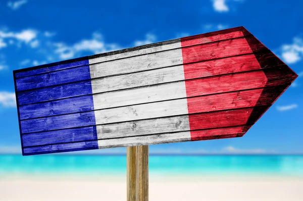 Sinal de madeira bandeira da França com em um fundo de praia — Fotografia de Stock