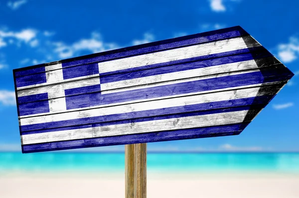 Yunanistan bayrağı ahşap plaj arka plan üzerinde oturum — Stok fotoğraf