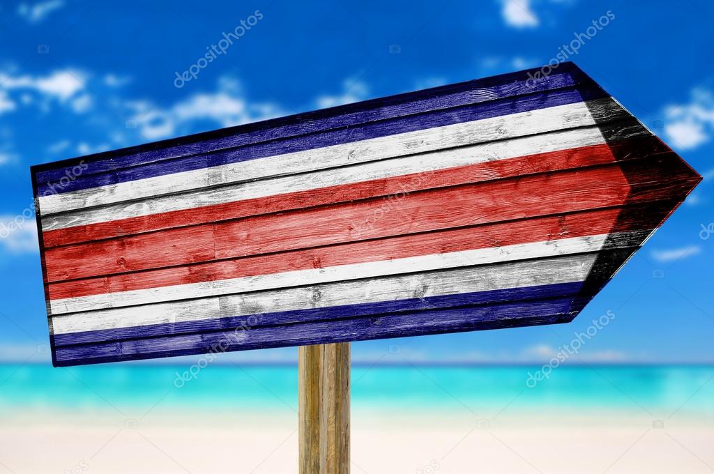 Costa Rica Flag wooden sign on beach background