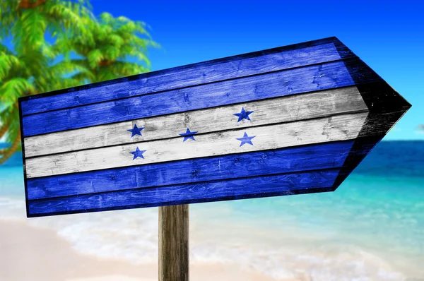 Bandeira de Honduras em placa de mesa de madeira no fundo da praia — Fotografia de Stock