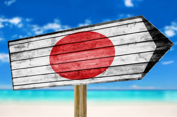 ビーチの背景に日本国旗木製サインします。 — ストック写真