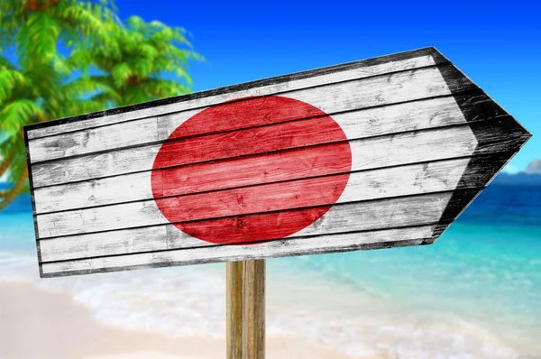 ビーチの背景に日本国旗木製サインします。 — ストック写真