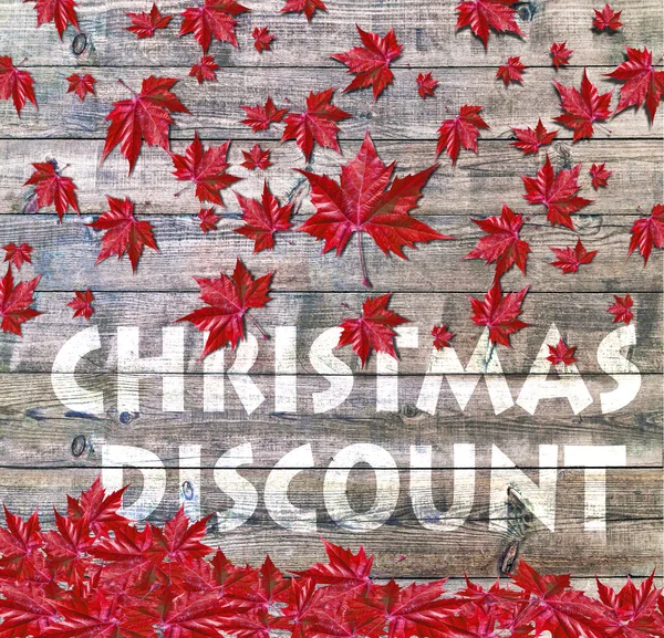 Weihnachtsrabatt und rotes fallendes Laub auf Holzgrund — Stockfoto