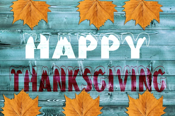 Happy Thanksgiving skrivit på blå trä bakgrund med blad — Stockfoto