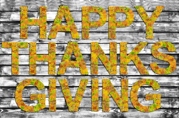 Happy Thanksgiving written on B&W wooden board with words made of leaves — Stock Photo, Image