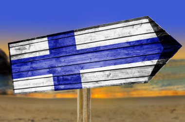 Finlandiya bayrağı ahşap plaj arka plan üzerinde oturum
