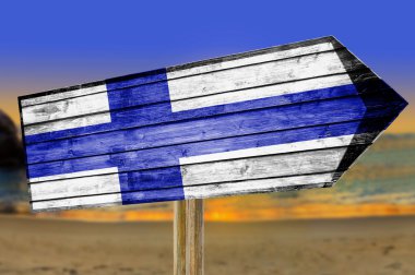 Finland Flag wooden sign on beach background clipart