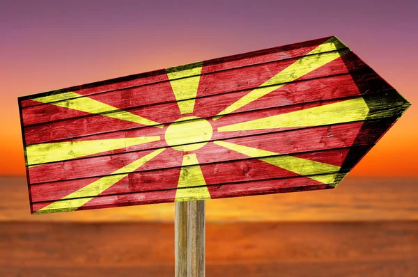 Cartel de madera con bandera de Macedonia sobre fondo de playa — Foto de Stock