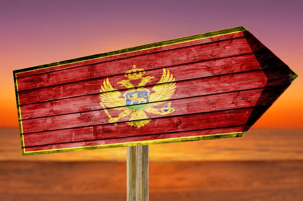 Montenegro Flag wooden sign on beach background — Stock Photo, Image