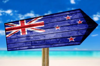 New Zealand Flag wooden sign on beach background clipart