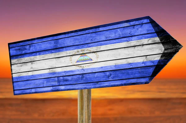 Bandera de Nicaragua letrero de madera sobre fondo de playa —  Fotos de Stock