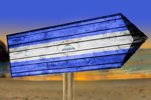 Bandera de Nicaragua letrero de madera sobre fondo de playa —  Fotos de Stock
