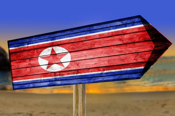ビーチの背景に北朝鮮国旗の木製看板 — ストック写真