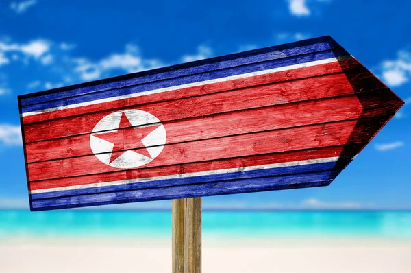 ビーチの背景に北朝鮮国旗の木製看板 — ストック写真