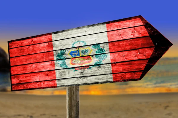 Bandera de Perú sobre mesa de madera cartel sobre fondo de playa — Foto de Stock