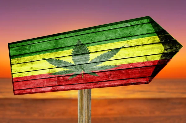 Plaj arka plan üzerinde marihuana yaprağı ile Rasta bayrak ahşap işareti