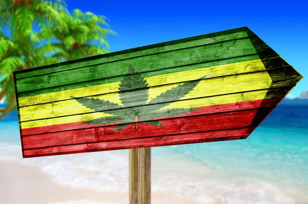 Rasta flagą z lisciem marihuany drewniany znak na tle plaży — Zdjęcie stockowe