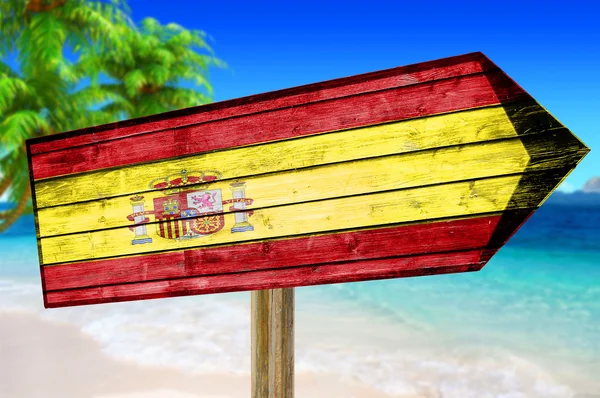 Vlajka Španělsko dřevěné podepsat na pláži pozadí — Stock fotografie