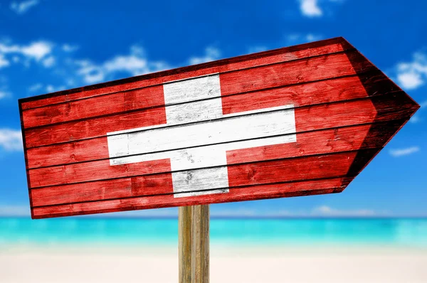 スイスの国旗木製サイン ビーチの背景 — ストック写真