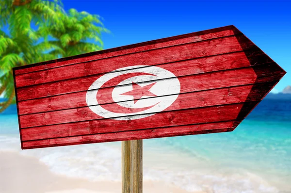 Tunus bayrağı ahşap plaj arka plan üzerinde oturum — Stok fotoğraf