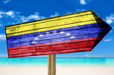 Venezuela Flag wooden sign on beach background clipart