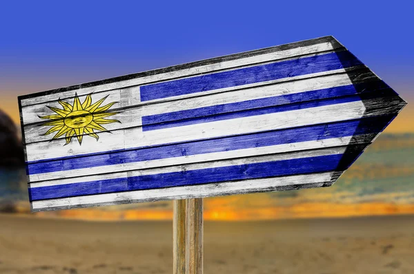Cartel de madera Bandera de Uruguay sobre fondo de playa —  Fotos de Stock