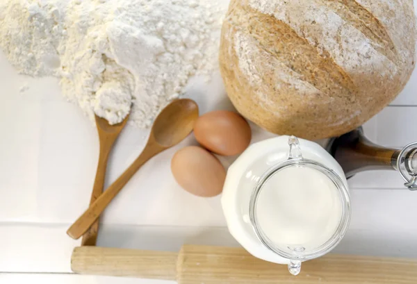 Fresh baked bread and ingredients for cooking, eggs, milk, flour