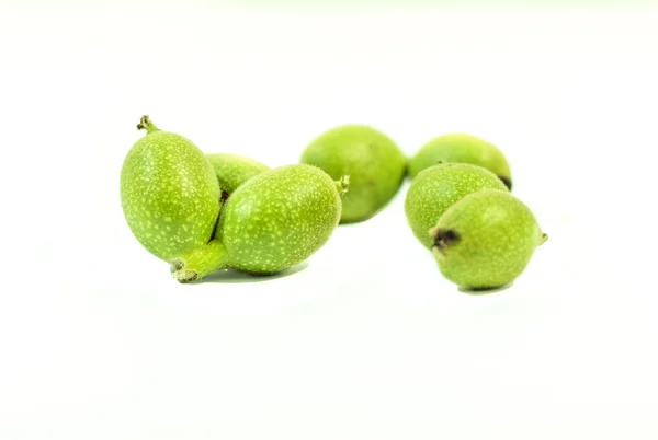 Зеленые молодые грецкие орехи на белом фоне — стоковое фото